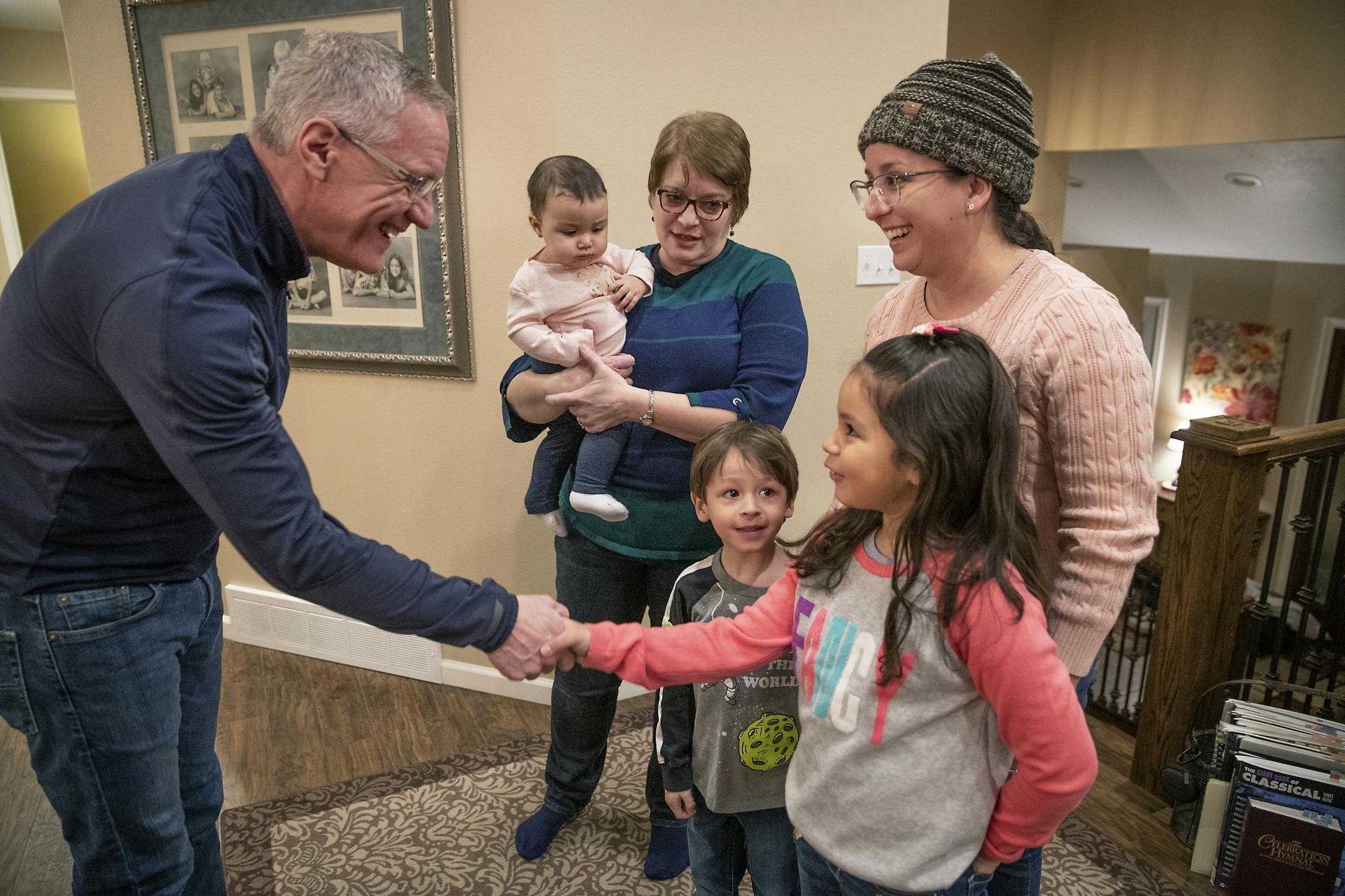 Pastor Steve Hoffer greeted Saylie Lopez Carrero's children including Sophia, 7, and Eythan, 4, during a dinner the Hoffers hosted for the new families from Puerto Rico, Sunday, February 16, 2020 in Roseau, MN. Hoffer's wife Mary Hoffer held onto 8-month-old Gia, the daughter of Harley Lebron and Gabriela Ferrao. Saylie Lopez Carrero, from Jayuya, PR, moved to Roseau last December.