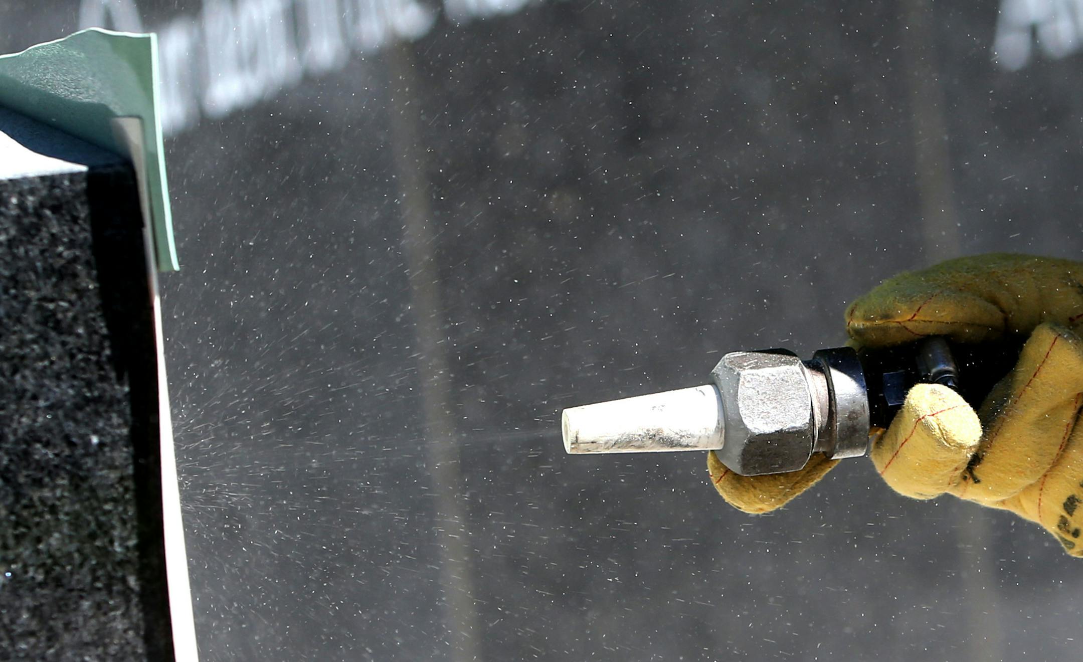 Engraver Wayne Winkelman, who owns and operates Winkelman Cemetery Lettering in St. Cloud, used a sand blaster to engrave the names of the first to go onto the Minnesota black granite Memorial Memoral Tuesday, June 16, 2015, near the southwest corner of the Hilde Performance Center at 3500 Plymouth Blvd. in Plymouth, MN. ](DAVID JOLES/STARTRIBUNE)djoles@startribune.com Plymouth is honoring area veterans with a new memorial that will be unveiled this month. Crews started work on engraving names o