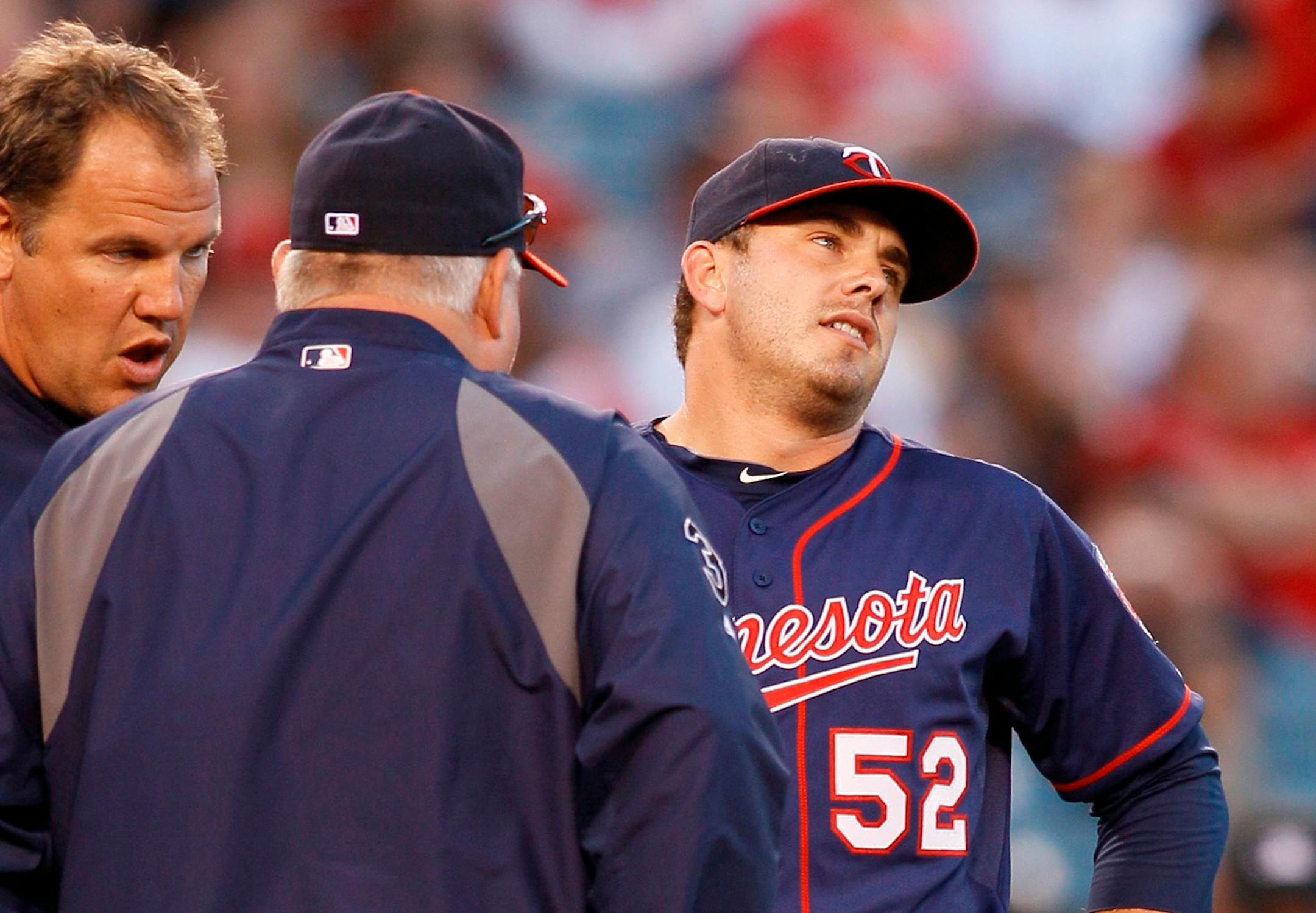 Minnesota Twins starting pitcher Brian Duensing (52) leaves the game with an injury as manager Ron Gardenhire, left, talks to him during the second inning of their baseball game against the Los Angeles Angels in Anaheim, Calif., Saturday, Sept. 3, 2011. (AP Photo/Lori Shepler)