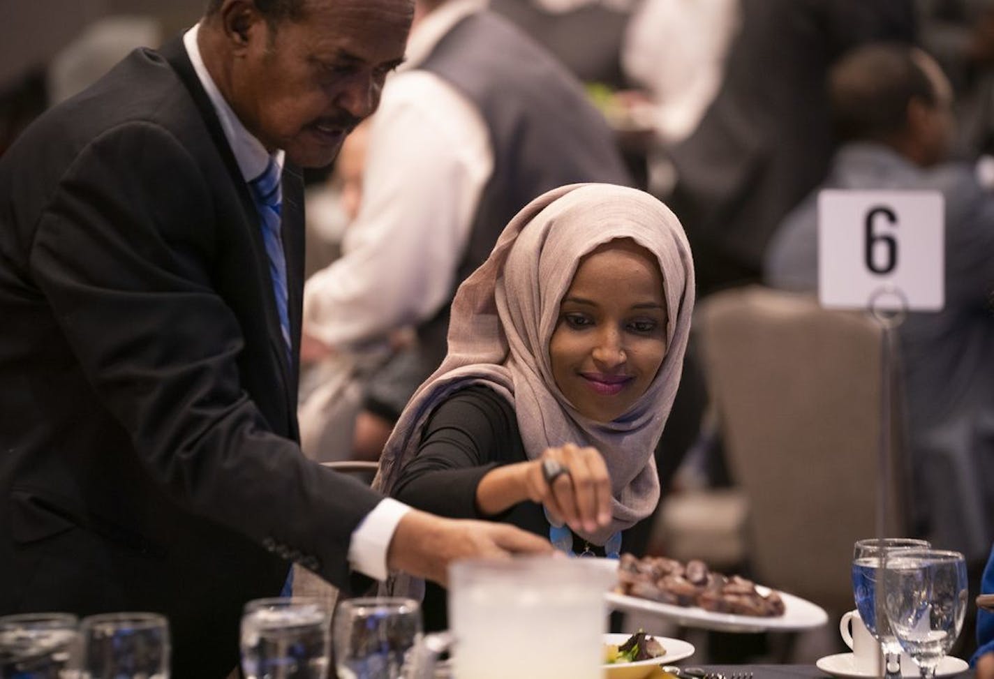 U.S. Rep. Ilhan Omar grabbed a date off a plate offered by her father, Nur Omar Mohamed, as iftar commenced.