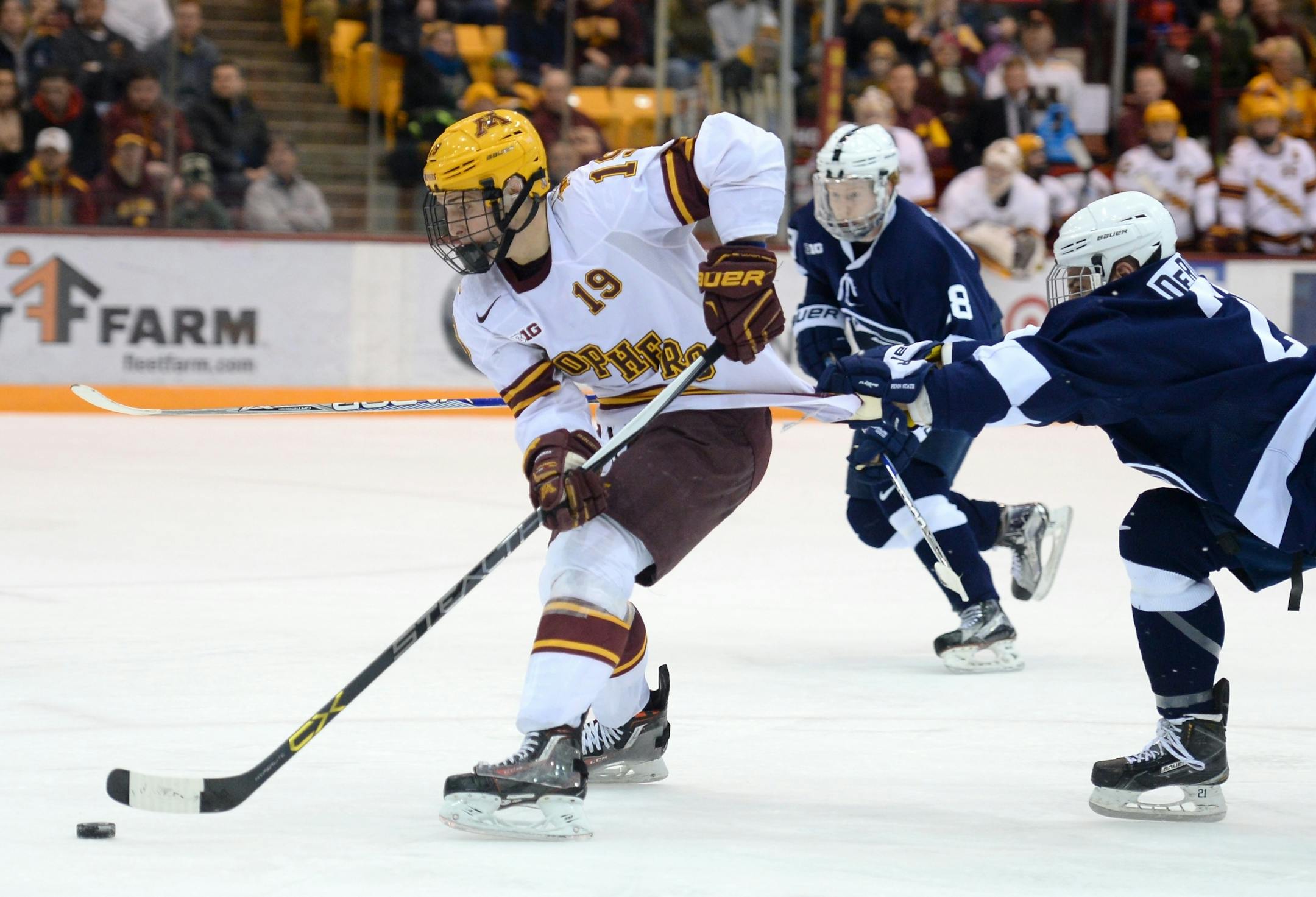 Penn State Nittany Lions forward Ricky DeRosa (21) held the jersey of Minnesota Golden Gophers center Vinni Lettieri (19) as Lettieri tried break away in the second period Friday.