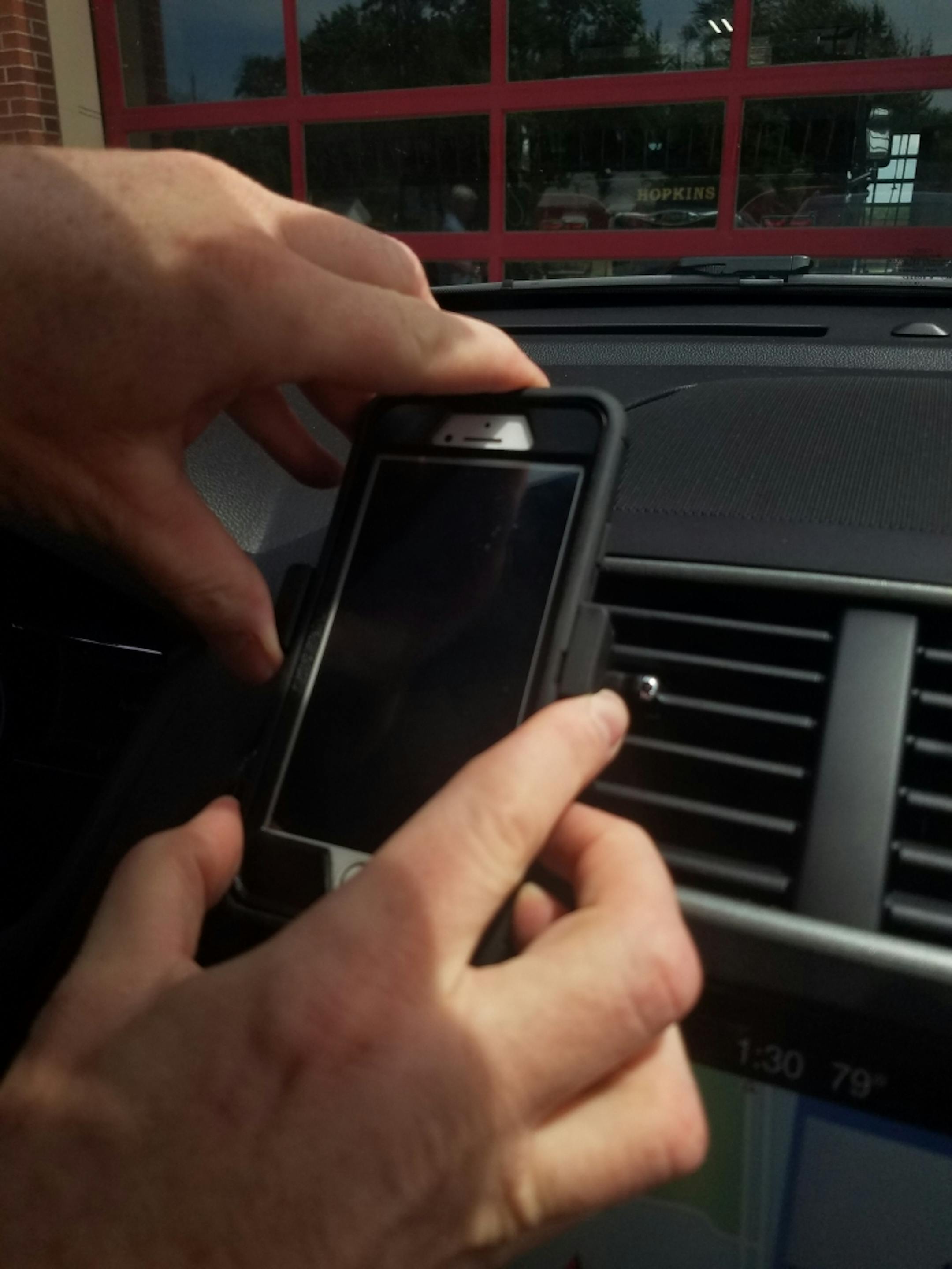Hopkins police are handing out plastic phone clips that fasten onto an air vent, allowing drivers to mount their phones and comply with the state's new hands-free law that takes effect Aug. 1.