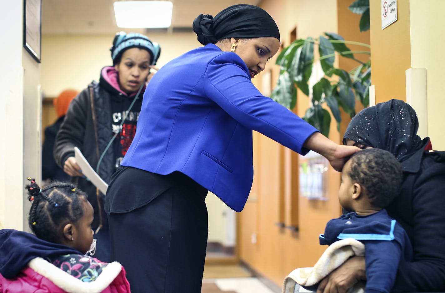 Sahra Noor touched the head of a little boys head to feel his temperature as she talked with patients waiting to be seen at The People&#x201a;&#xc4;&#xf4;s Center Health Services in Minneapolis, Minn. on Monday, December 22, 2014. ] REN&#x221a;&#xe2;E JONES SCHNEIDER reneejones@startribune.com ORG XMIT: MIN1412221755480306