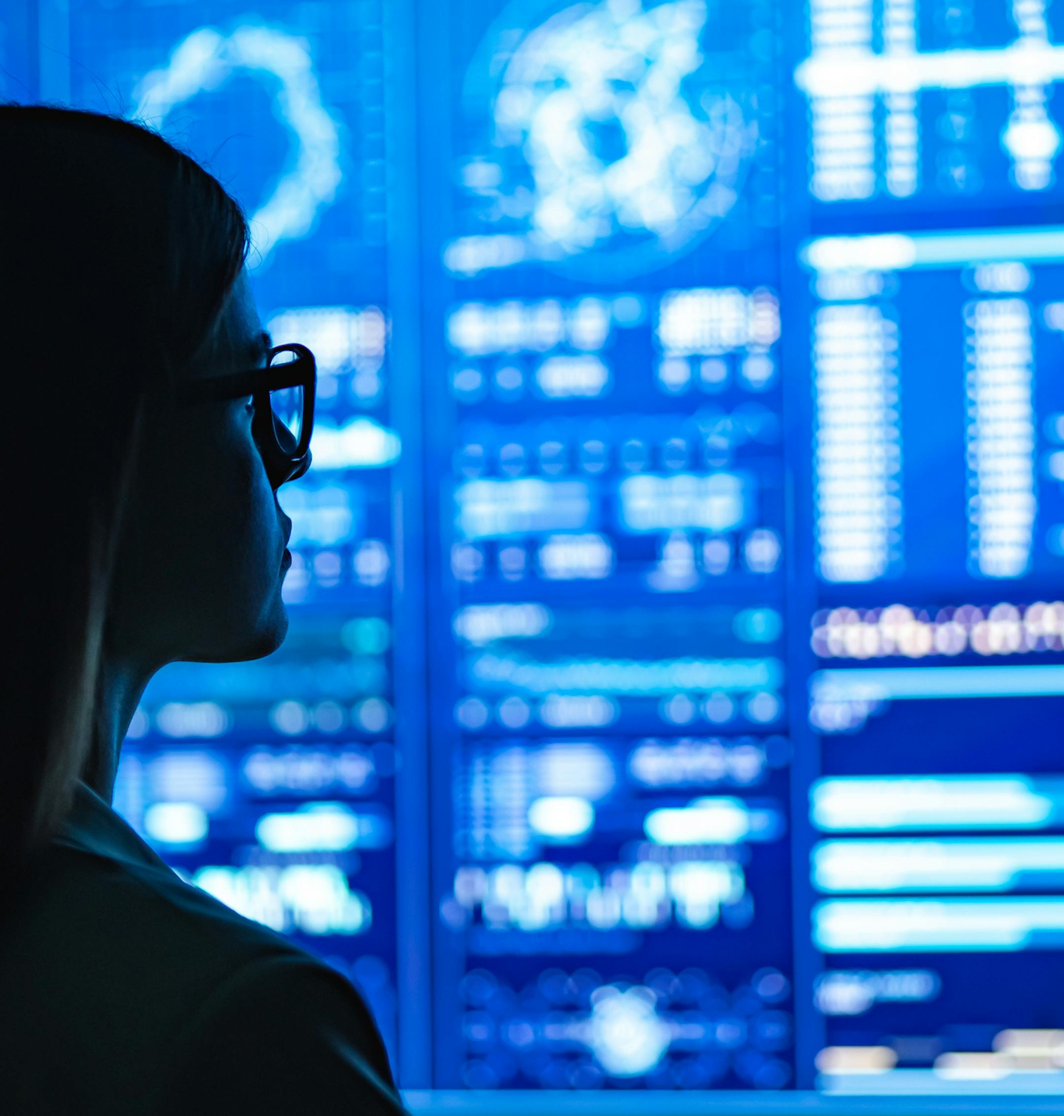 The businesswoman standing near the blue display