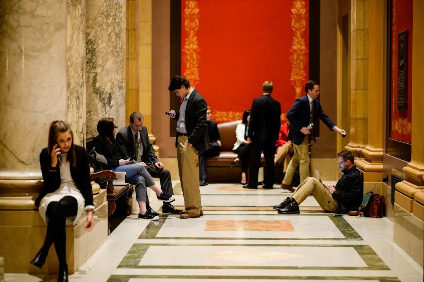 Staffers and lobbyists waited in the hall outside the House chamber Tuesday night during a recess in the legislative special session.