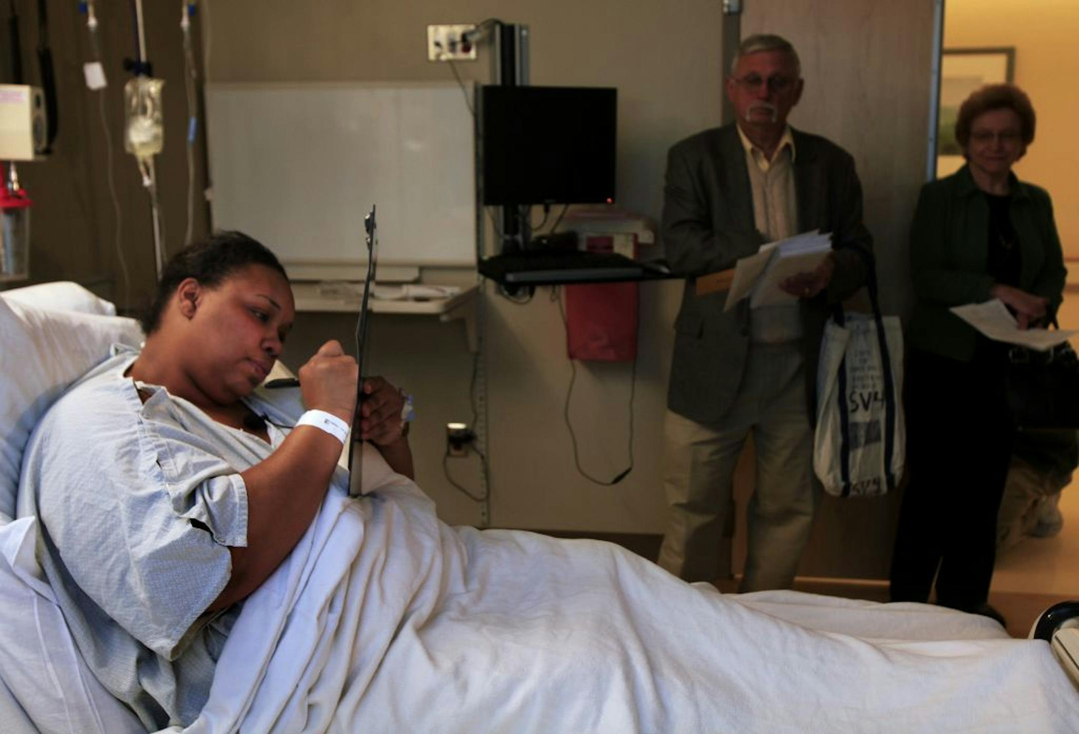 Regions Hospital patient Lashelle Coleman voted from her bed on Monday. Election judges Larry Klueh and Romayne Houle acted as witnesses.