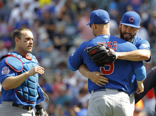 Chicago Cubs starting pitcher Jake Arrieta, right, and catcher Miguel Montero, left, celebrate with David Ross (3) after the Cubs defeated the Minneso