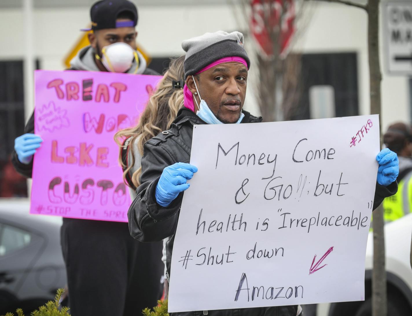 Gerald Bryson, left, join workers at an Amazon fulfillment center in Staten Island, N.Y., protesting conditions in the company's warehouse, Monday March 30, 2020, in New York. Workers say Amazon is not doing enough to to keep workers safe from the spread of COVID-19. "They say we going by CDC standards, but when we call the CDC they are not," said Bryson. "I got grand kids at home, I got kids, I am not doing it." (AP Photo/Bebeto Matthews)