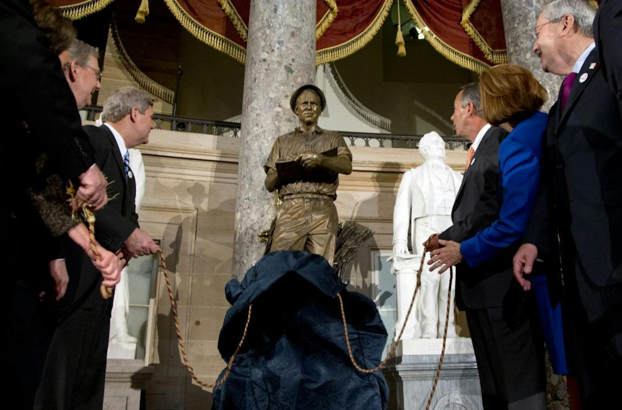 Dignitaries look to a statue of the late Dr. Norman E. Borlaug during its unveiling in National Statuary Hall on Capitol Hill in Washington, Tuesday, March 25, 2014.