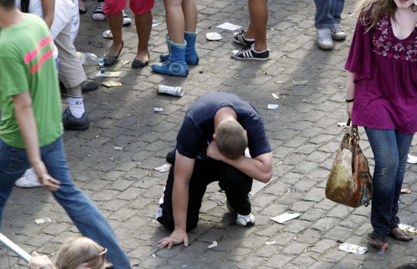 A participant rests exhausted after a panic on this year's techno-music festival "Loveparade 2010" in Duisburg, Germany, on Saturday, July 24, 2010. German police say that 10 people were killed and 15 others injured when mass panic broke out in a tunnel at the Love Parade.