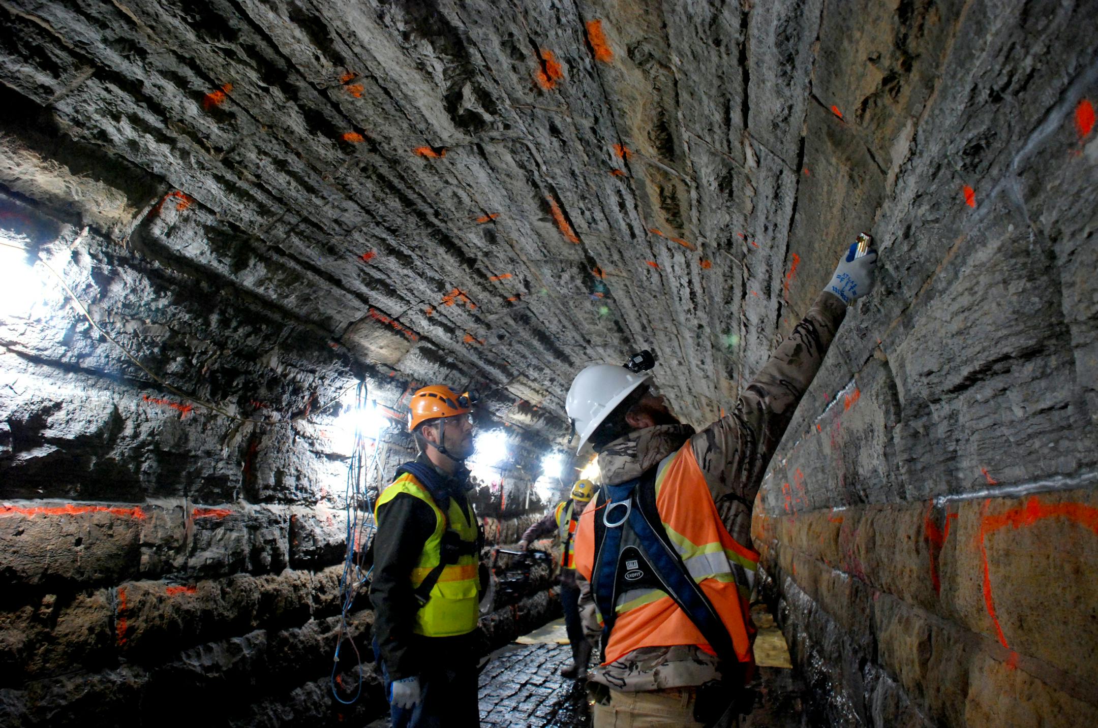 Workers inspect storm sewer.