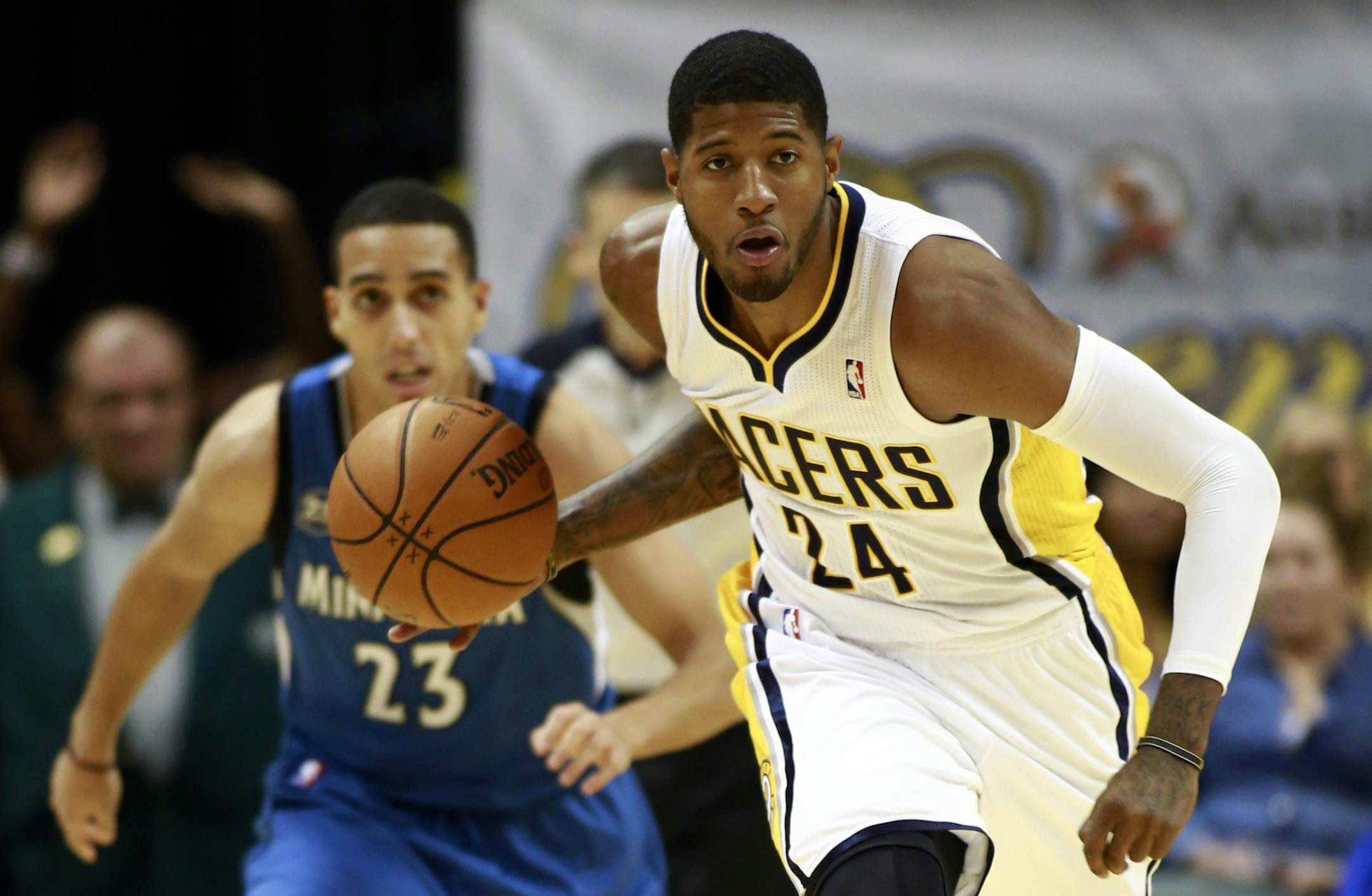 Indiana Pacers forward Paul George (24) brings teh ball up while followed by Minnesota Timberwolves guard Kevin Martin in the second half of an NBA basketball game in Indianapolis, Monday, Nov. 25, 2013. Indiana won 98-84. (AP Photo/R Brent Smith)