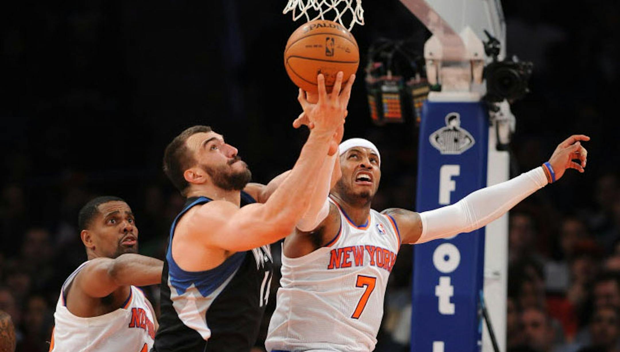 Minnesota's Nikola Pekovic (14) and New York's Carmelo Anthony (7) battle for a rebound.