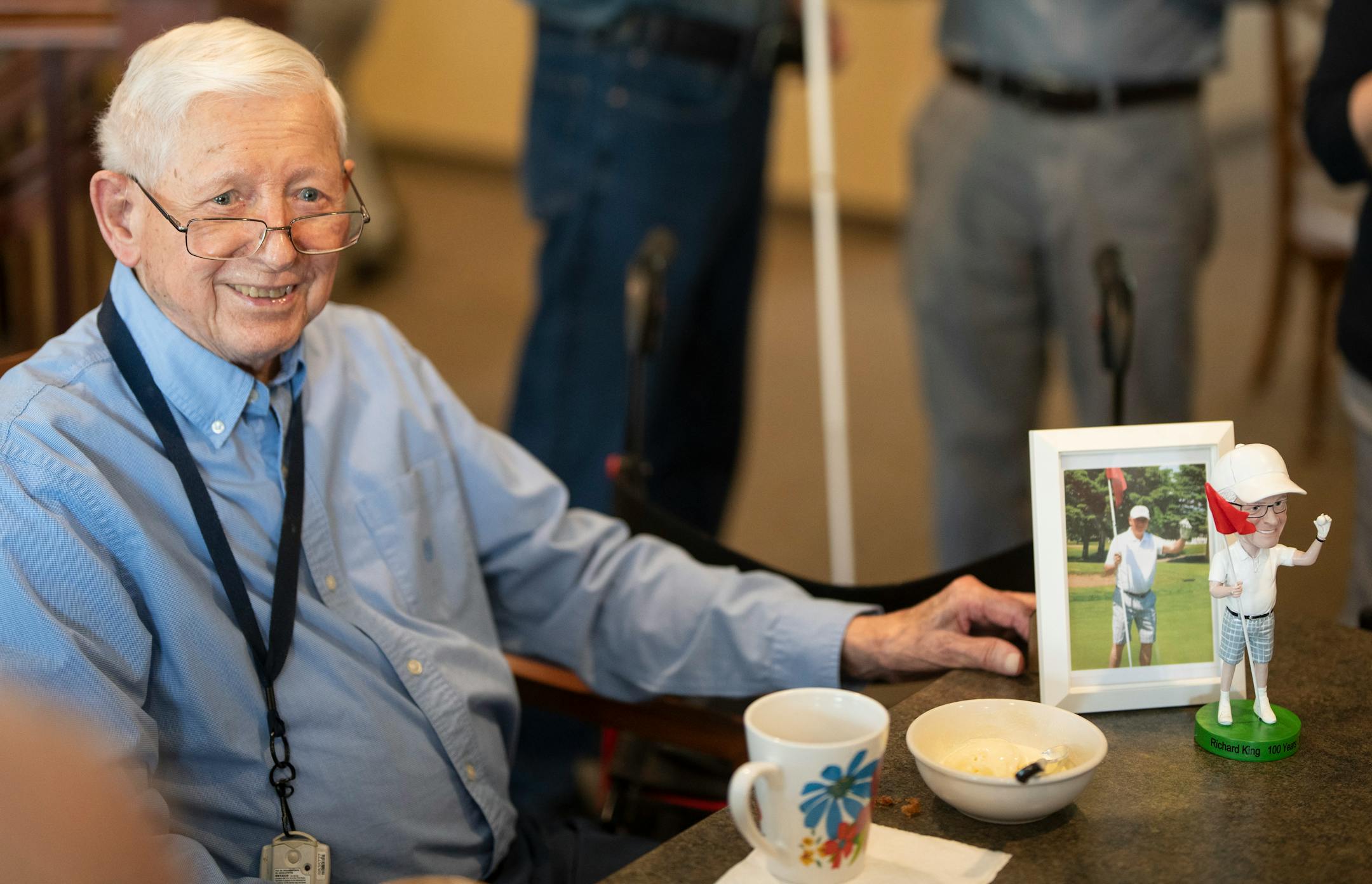Richard King showed a custom made bobblehead inspired from a picture of him after scoring a hole-in-one he got as a gift from his daughter for his 100th birthday while celebrating with fellow residents and staff at his home New Perspective Woodbury senior facility in Woodbury, Minn., on Thursday, June 8, 2023.