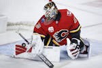 FILE - In this Jan. 28, 2020, file photo, Calgary Flames goalie Cam Talbot deflects a shot during the second period of an NHL hockey game against the 