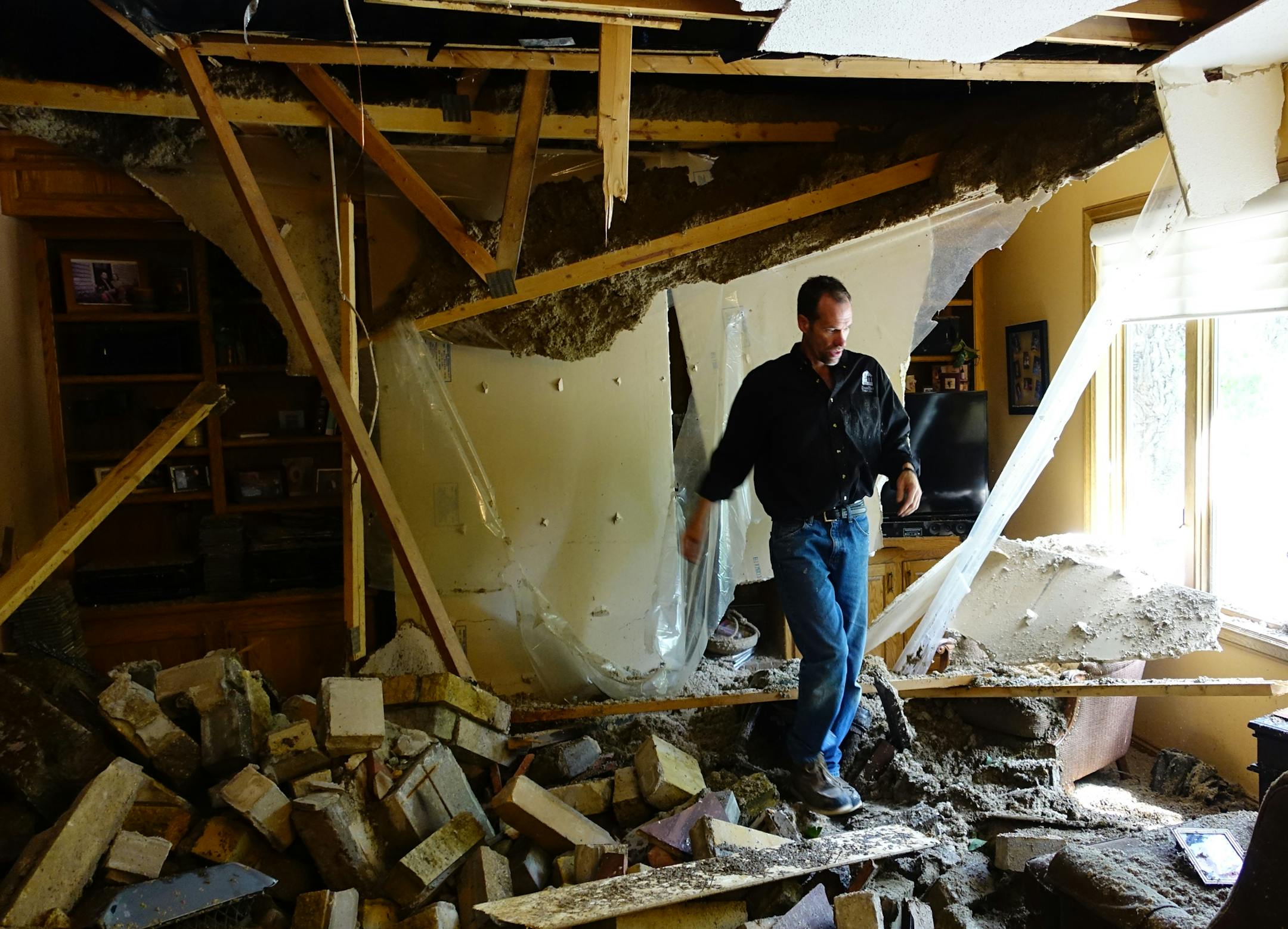 A large cottonwood tree uprooted and fell onto the home of Jon and Mary Arntson during the severe thunderstorms Tuesday and seen Wednesday, July 6, 2016, in Maple Grove, Minn. Here, contractor Frank Morrisette of Gran Mar Homes looks through the living room for structural damage. ] (SHARI L. GROSS/STARTRIBUNE)sgross@startribune Strong thunderstorms brought heavy rains and punishing winds through the metro area early Tuesday evening, causing this cottonwood tree to crash onto the home of Jon and