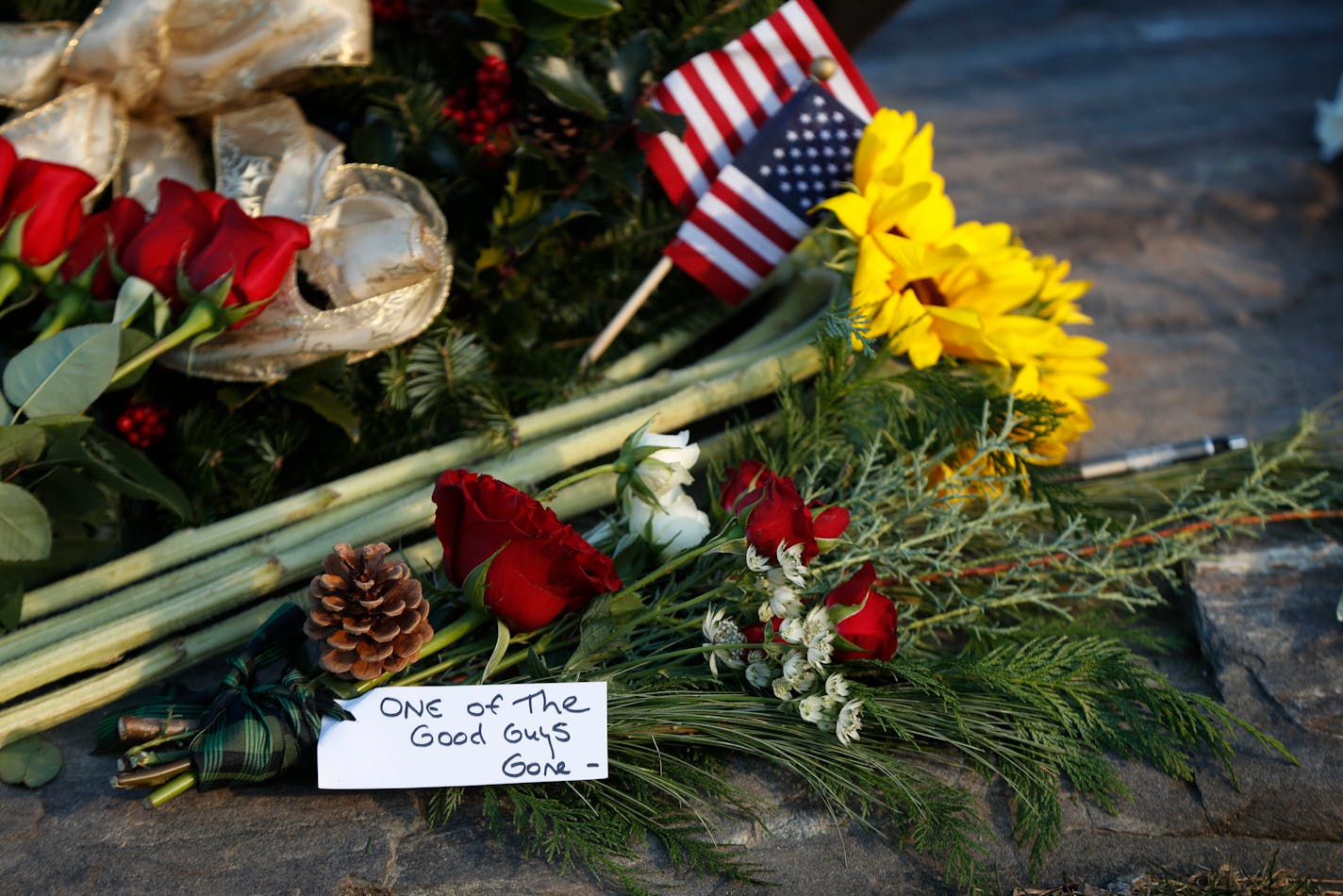 Flowers and a note saying former President George H. W. Bush was "one of the good guys," are seen at a makeshift memorial across from Walker's Point, the Bush's summer home, Saturday, Dec. 1, 2018, in Kennebunkport, Maine. Bush died at the age of 94 on Friday, about eight months after the death of his wife, Barbara Bush.