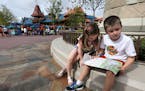 Calum Carpenter, 7, with his sister Eden, 5, reads a guide map while visiting from New York City with his parents, Mike and Elaine Carpenter, at Walt 