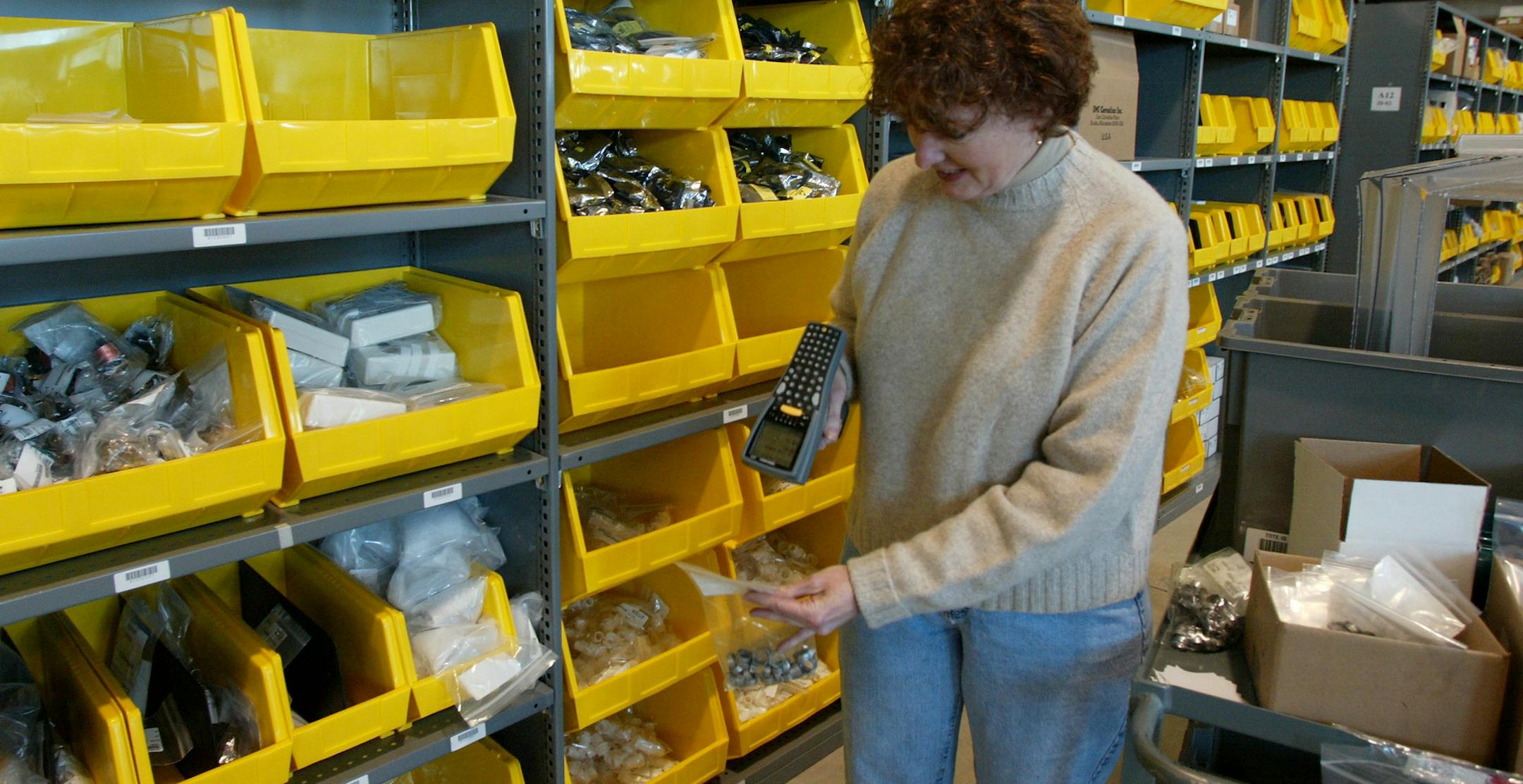 GENERAL INFORMATION: OSSEO, MN - FRI - 3/15/2002 - HighJump makes software that helps companies such as Bevcore Solutions run their warehouses. Since this is a story about a software company, the photo is somewhat elusive to me.
IN THIS PHOTO: Joy Kowalski, a Distribution Center Associate for Bevcore uses a handheld scanner device which guides her to product bins, tells her how many of what and in general is her robotic servant.