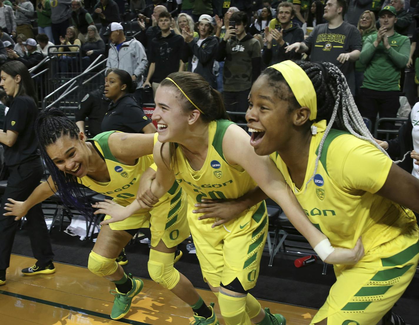 Oregon's Satou Sabally, left, Sabrina Ionescu and Ruthy Hebard, right, come off the bench in celebration of the team's 78-40 victory over Portland State in a first-round game of the NCAA women's college basketball tournament Friday, March 22, 2019, in Eugene, Ore. (AP Photo/Chris Pietsch) ORG XMIT: ORCP122