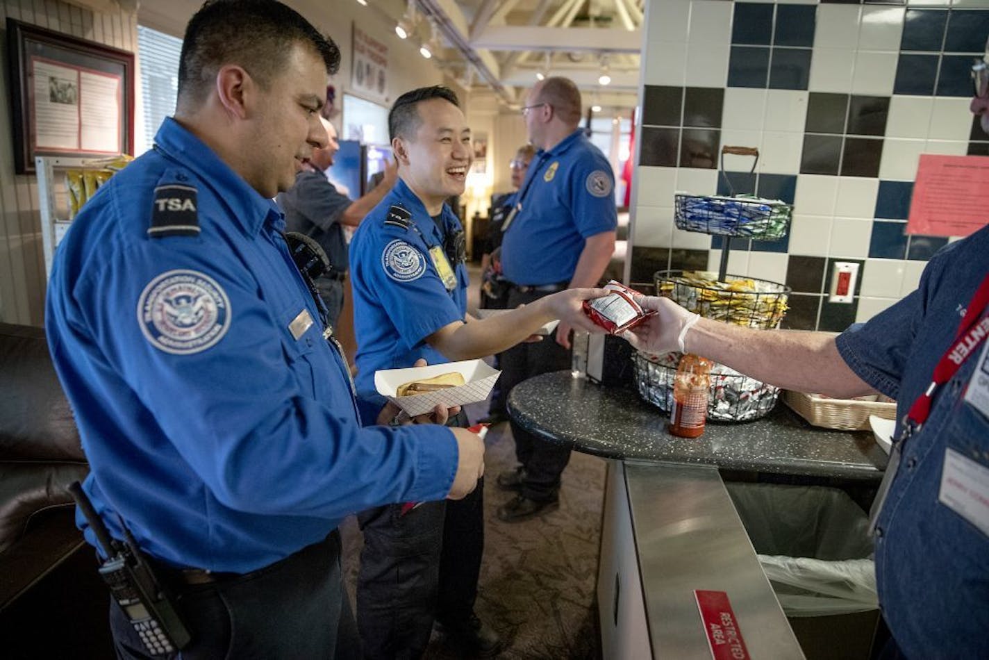 Hector Caballero, left, and Dai Vang were all smiles after receiving complimentary hot dogs and chips from the Armed Forces Service Center at MSP Airport, Thursday, January 17, 2019 in Bloomington, MN.