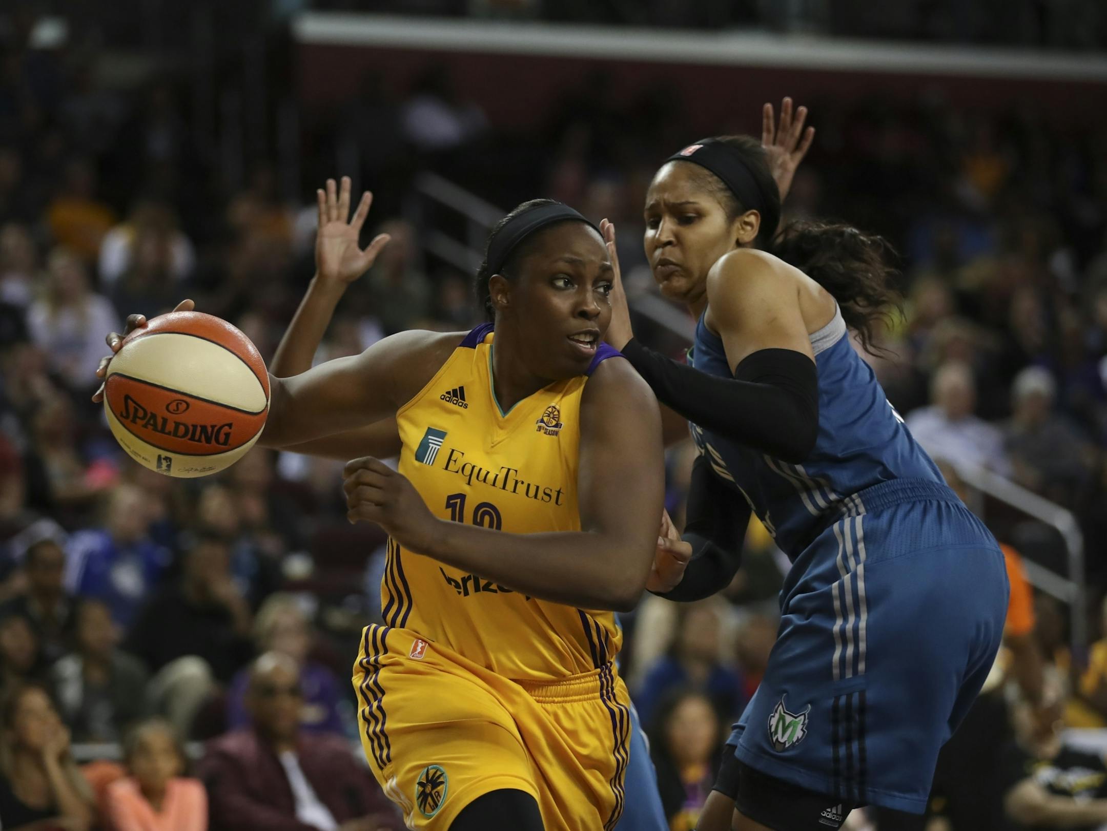 Los Angeles Sparks guard Chelsea Gray (12) drove through the paint while defended by Minnesota Lynx guard Renee Montgomery (21) and forward Maya Moore