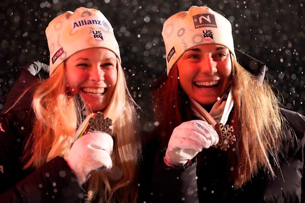 Americans Jessie Diggins and Julia Kern posed on the podium with their bronze medals during the medal ceremony for the women's cross country team spri