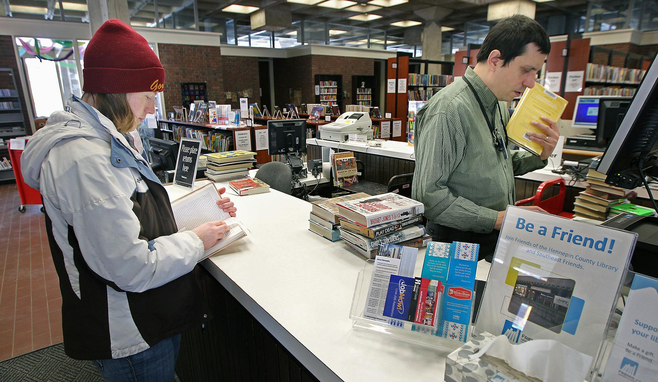 U of M student Katherine Wippler, cq, checked out and returned a book with the assistance of Jim Ruiz, the office specialist, at the Southeast Minneapolis Public Library, Thursday, February 11, 2016 in Minneapolis, MN. ] (ELIZABETH FLORES/STAR TRIBUNE) ELIZABETH FLORES • eflores@startribune.com