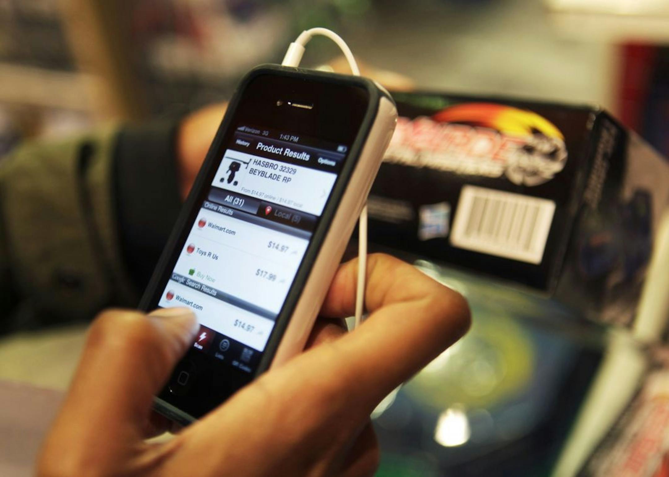 Robert Drayton uses his smartphone to help him find the right gifts and compare prices at Toys R Us in New York, Monday, Nov. 28, 2011. Shoppers seem to be just as enthusiastic about shopping on their computers and smartphones on Cyber Monday as they were about finding deals over the Black Friday weekend.