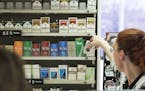 Michelle Kennedy grabbed a back of cigarettes behind the counter for a customer at Vernon BP gas station in Edina, Minn., on Tuesday, May 2, 2017. ] R