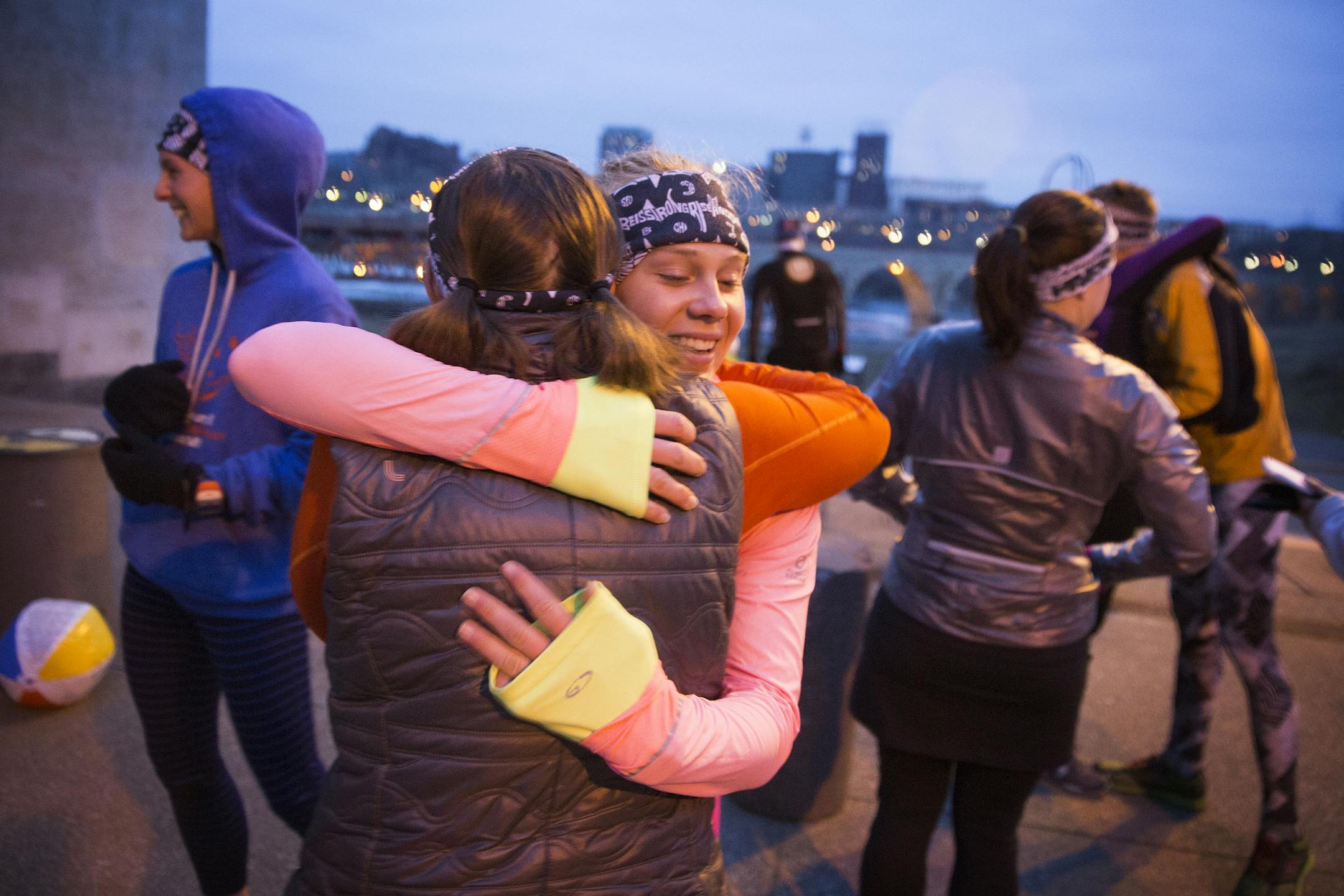 Melissa Somers, left, and Holly Rieland hug each other hello before a meeting of the November Project workout group in downtown Minneapolis on Wednesday, April 8, 2015. ] LEILA NAVIDI leila.navidi@startribune.com / BACKGROUND INFORMATION: The November Project is a flash-mob style free workout movement that meets every Wednesday at 6:27 a.m. in downtown Minneapolis to work out and build community.