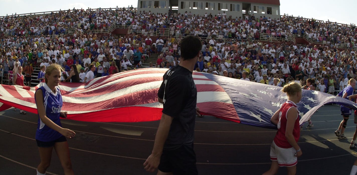 SUNDAY_07/15/01_Blaine - - - - The American flag was was carried in for the Natioan Anthem at the Schwan's USA Cup at the National Sports Center in Blaine Sunday night. ORG XMIT: MIN2014062815254325