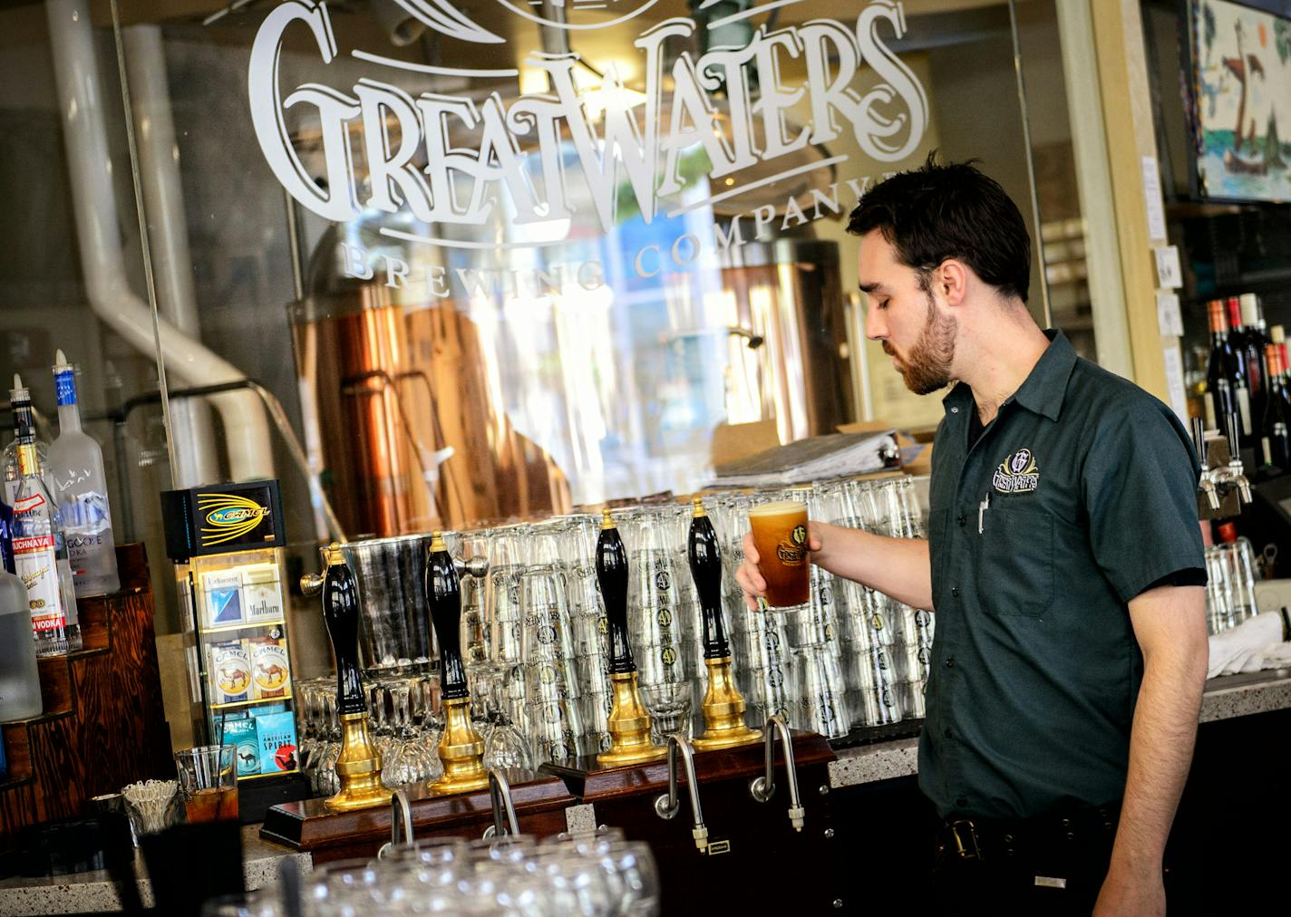 Bartender Sam Marquardt poured a beer at Great Waters Brewing Co., which has been brewing its British-style cask beer at the historic Hamm building&#x2019;s ground floor since 1997.