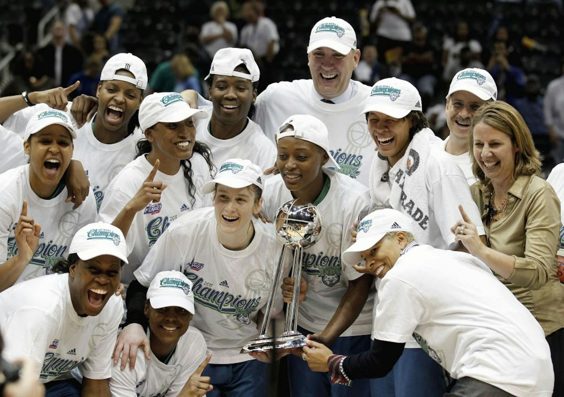 Members of the Minnesota Lynx hold the championship trophy, center, after defeating the Atlanta Dream 73-67 to complete a three-game sweep of the WNBA championship series, Friday, Oct. 7, 2011, in Atlanta.