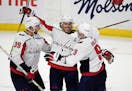 Washington Capitals right wing T.J. Oshie (77) celebrates his hat trick goal against the Ottawa Senators with right wing Anthony Mantha (39) and defen