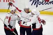 Washington Capitals right wing T.J. Oshie (77) celebrates his hat trick goal against the Ottawa Senators with right wing Anthony Mantha (39) and defen