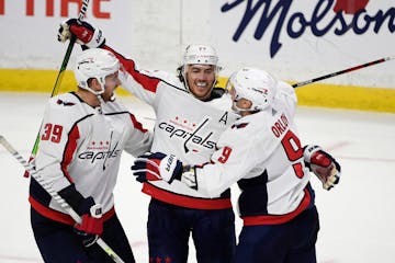 Washington Capitals right wing T.J. Oshie (77) celebrates his hat trick goal against the Ottawa Senators with right wing Anthony Mantha (39) and defen