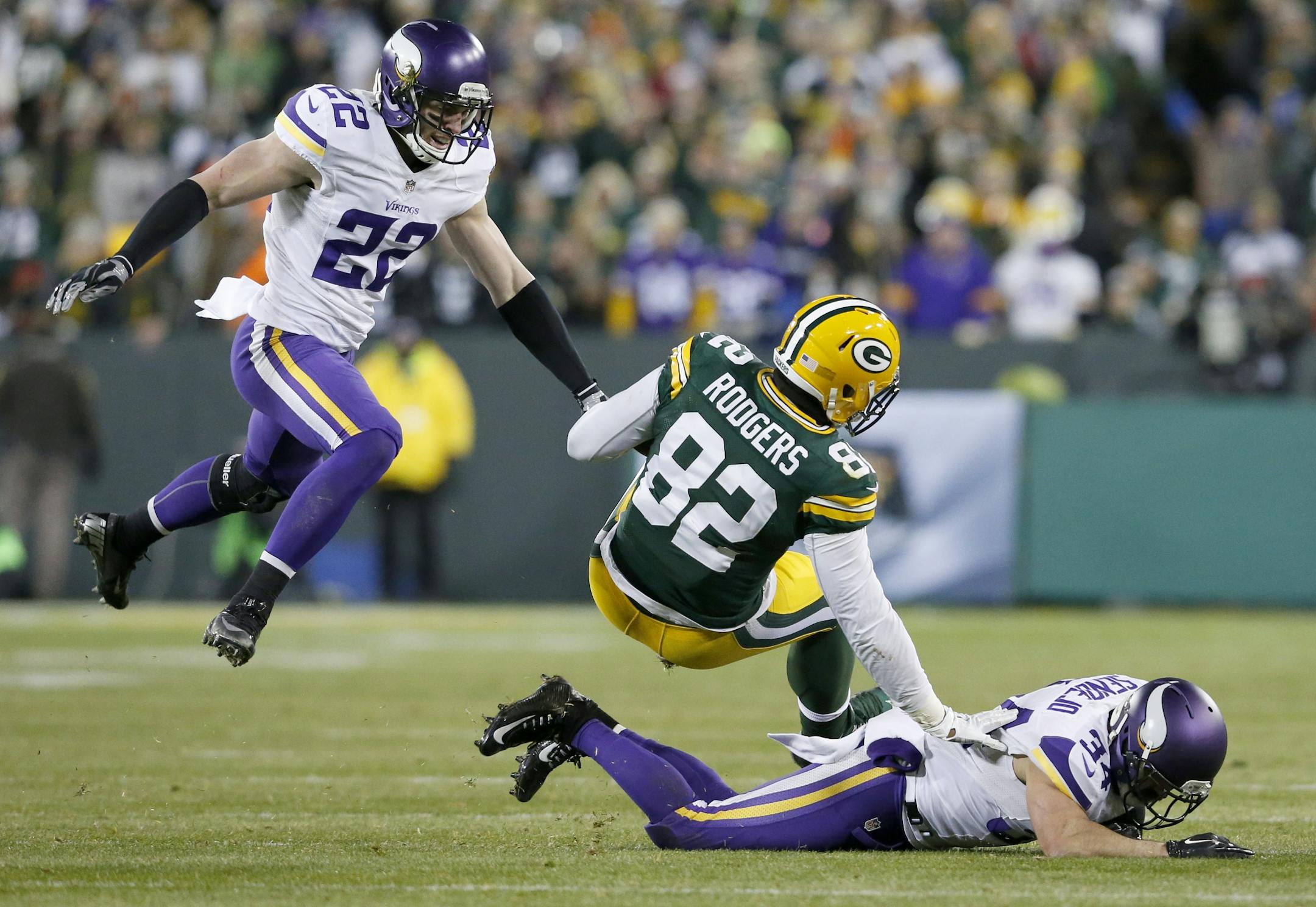 Vikings safeties Harrison Smith (22) and Andrew Sendejo (34) tackled Green Bay's Richard Rodgers.