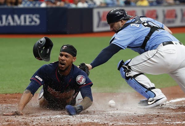 The Twins' Byron Buxton slid home to score in front of Tampa Bay catcher Mike Zunino during the fifth inning Sunday.