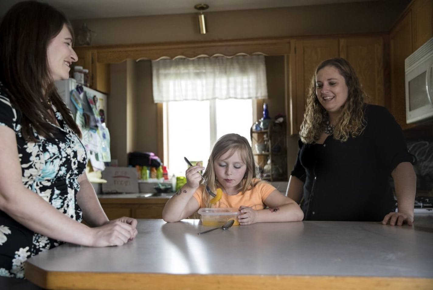 Real estate agent Joslyn Solomon, left, chatted with Erin Simonson, right, as her daughter ate peaches in the kitchen. She was visiting to discuss what Simonson should list her house for later this summer. Simonson lives in Zimmerman, Minn., and is hoping to put her house on the market later this summer. She bought the home at the housing peak. Photographed on May 4, 2017.