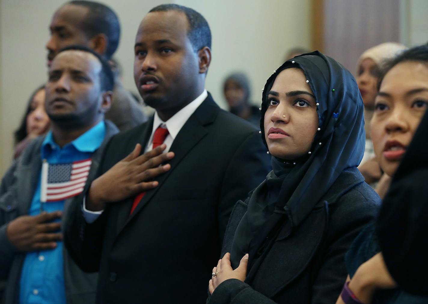 Beenish Saleem, cq, right, of Pakistan, joined others as they cited the Pledge of Allegiance during a Citizen naturalization ceremony at the Richfield City Hall, Tuesday, February 16, 2016 in Richfield, MN. ] (ELIZABETH FLORES/STAR TRIBUNE) ELIZABETH FLORES &#x2022; eflores@startribune.com