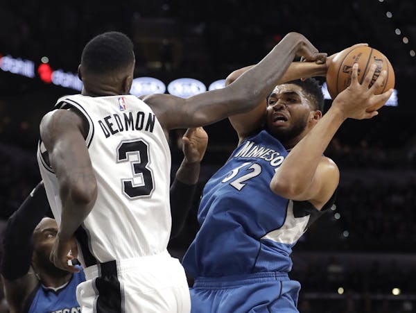 Minnesota Timberwolves center Karl-Anthony Towns (32) is fouled by San Antonio Spurs center Dewayne Dedmon (3) during the first half of an NBA basketb