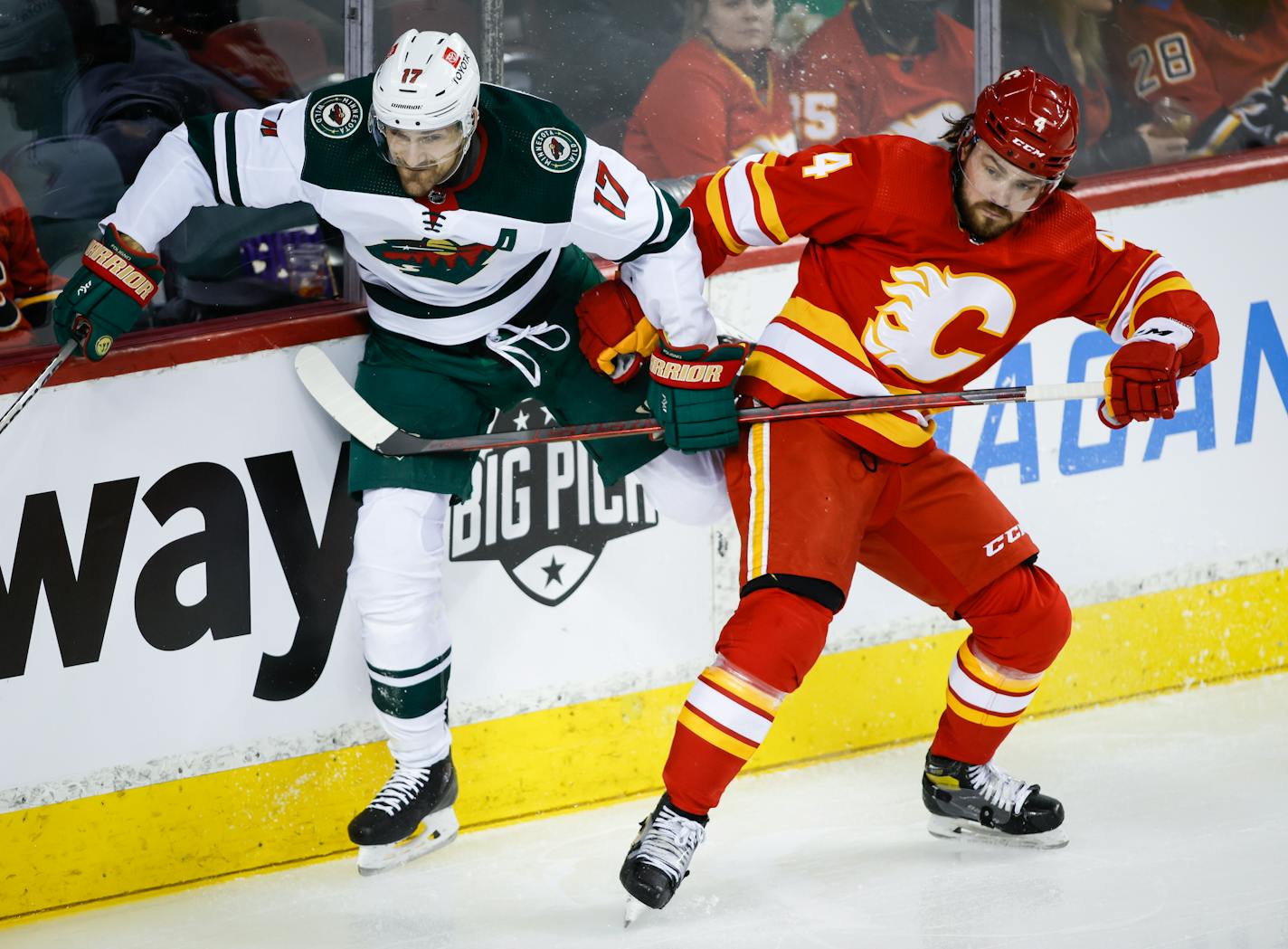 The Wild's Marcus Foligno is checked by Calgary's Rasmus Andersson during the second period of Saturday's game.