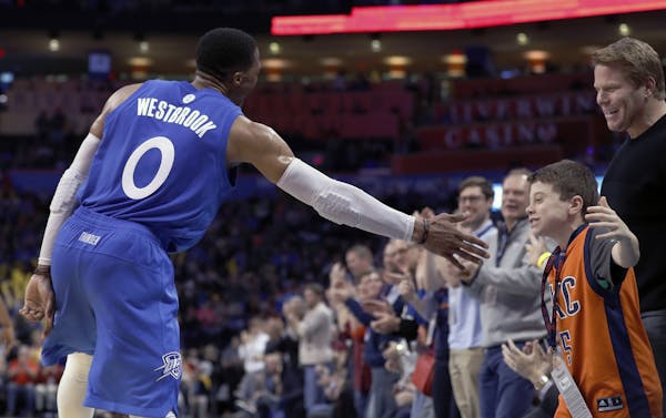 Oklahoma City Thunder guard Russell Westbrook (0) high-fives a fan after a play against the Minnesota Timberwolves in the second half of an NBA basket