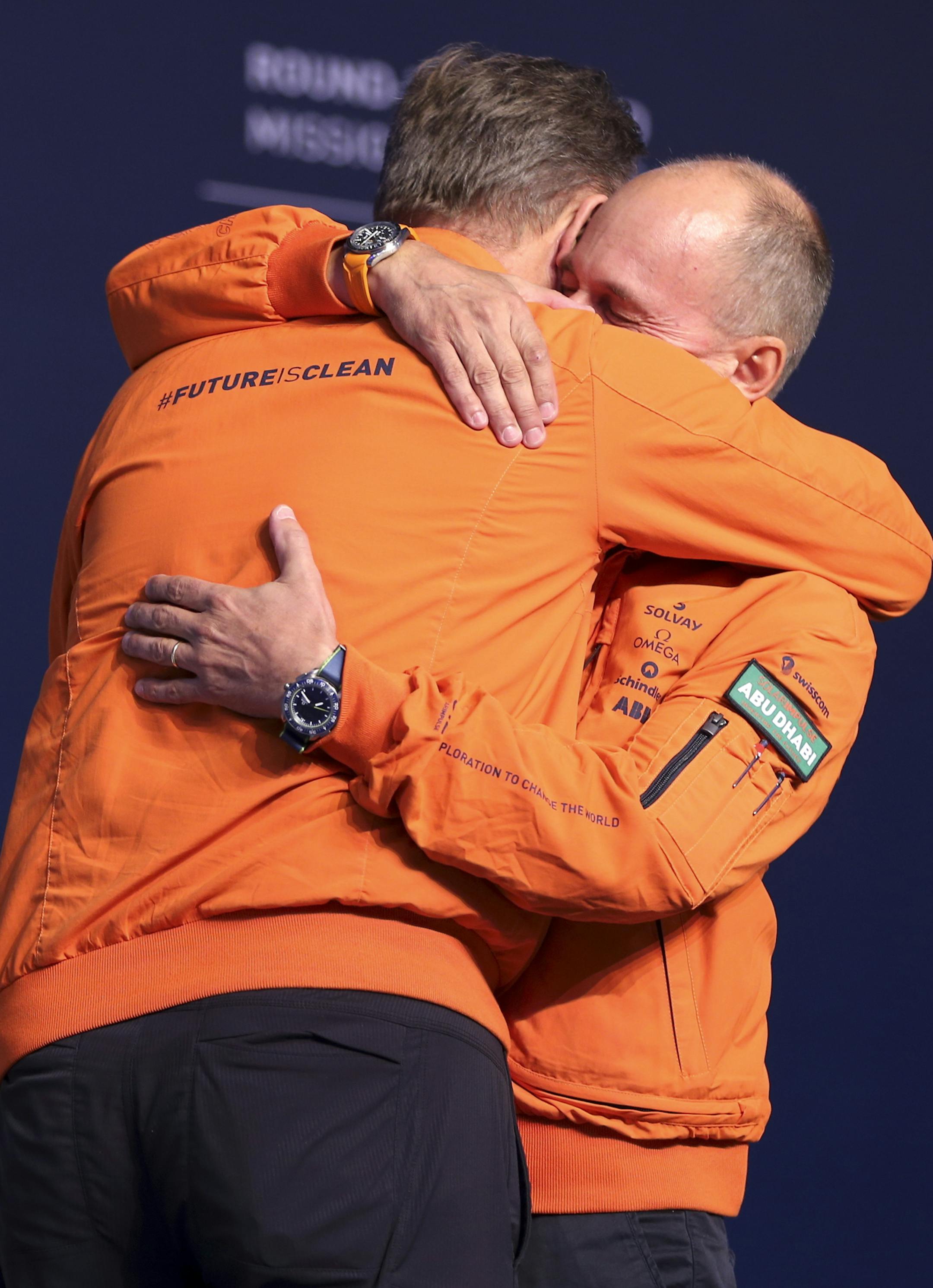 Bertrand Piccard, right, and Andre Borschberg, left, the pilots of the Solar Impulse 2 plane, embrace in Abu Dhabi, United Arab Emirates, on Tuesday, July 26, 2016. The world's first round-the-world flight to be powered solely by the sun's energy made history on Tuesday as it landed in Abu Dhabi, where it first took off on an epic 25,000-mile (40,000-kilometer) journey that began more than a year ago. (AP Photo/Adam Schreck)