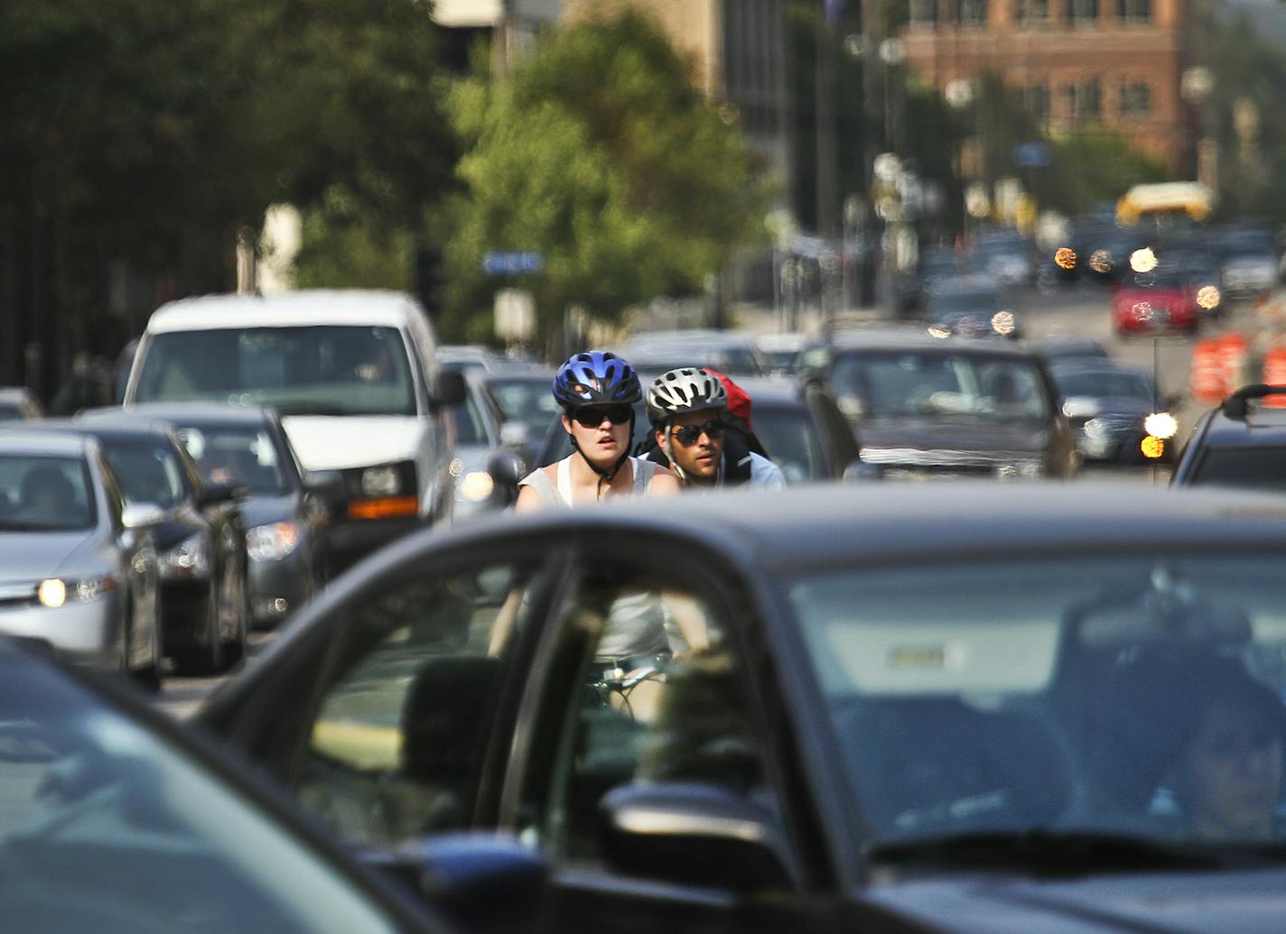 Bicyclists and cars co-exist while heading south in heavy traffic along Portland Ave., near E. Grant Street Thursday, Aug. 30, 2012, in Minneapolis, MN.] (DAVID JOLES/STARTRIBUNE) djoles@startribune.com Plenty of critics are expected to turn out Thursday night when Hennepin County unveils the new striping for Portland and Park avenues that turns over current driving space to bikers. The plan to cut what have been described as the city's mini-freeways from three to two lanes for a better-buffered