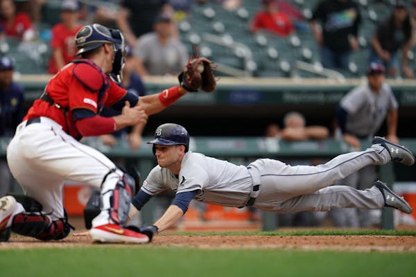 Tampa Bay Rays second baseman Brandon Lowe (8) dove save into home ahead of the tag by Minnesota Twins catcher Jason Castro (15) for the game winning 