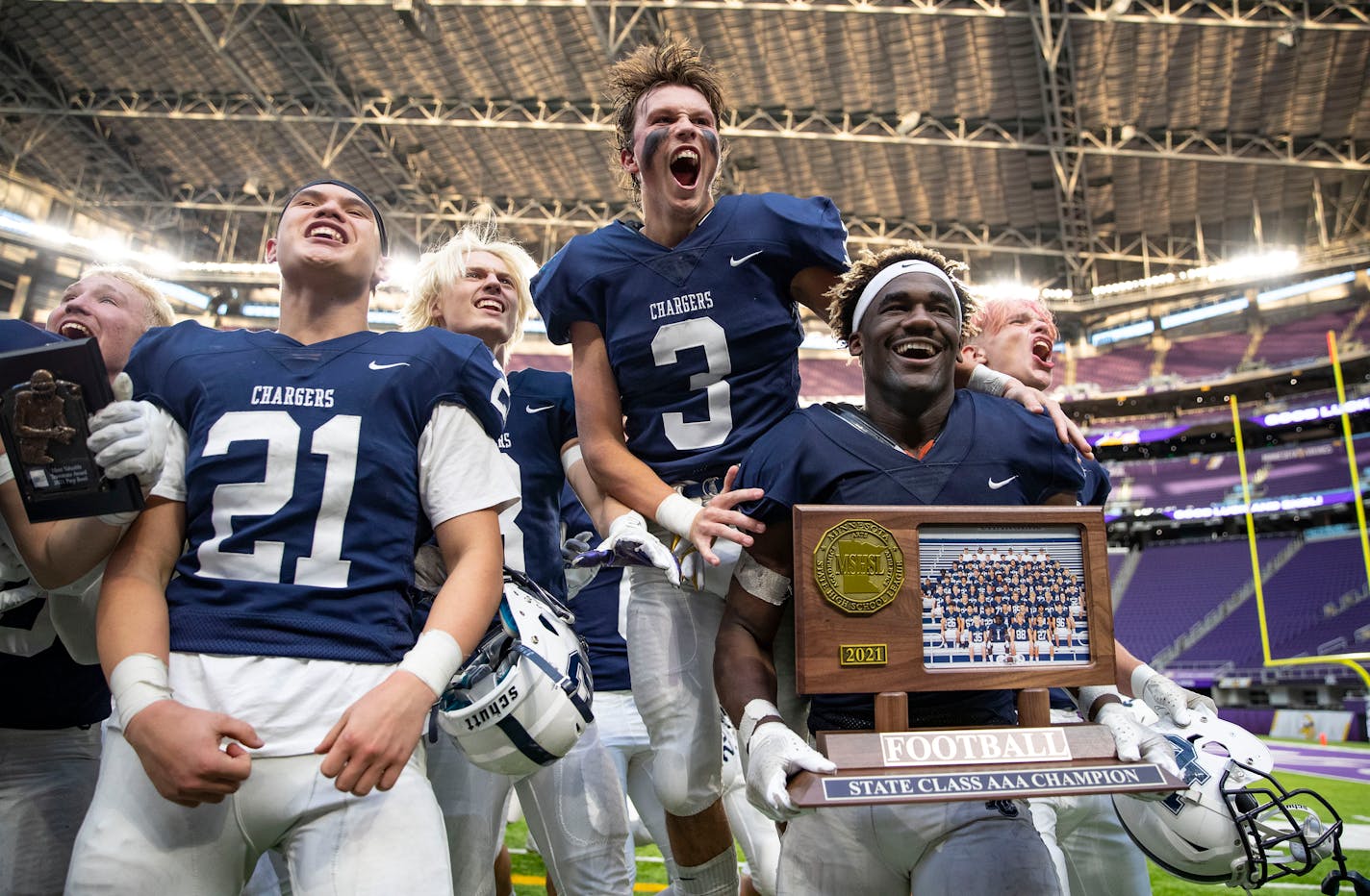 Dassel-Cokato High School players Devan Nguyen (21), Grant Haataja (3) and Eli Gillman (1), left to right, celebrate with their teammates after defeating Plainview-Elgin-Millville High School 28-21 in the Minnesota High School football Class 3A State Championship Saturday, Nov. 27, 2021 at U.S. Bank Stadium in Minneapolis. ]