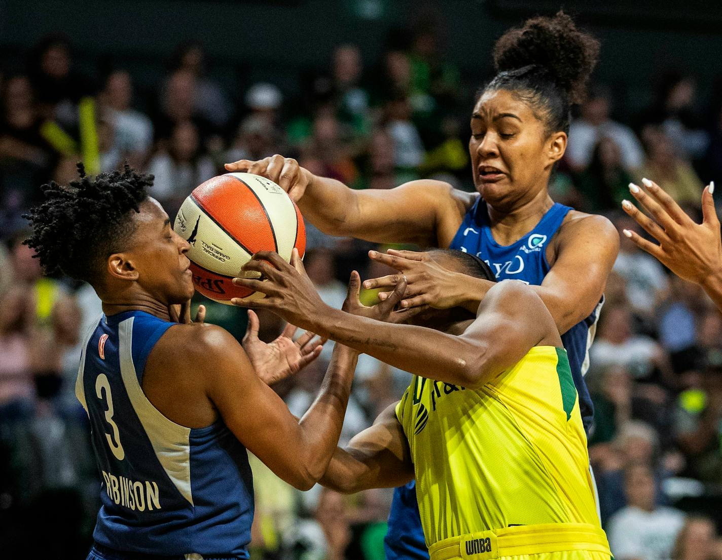 Seattle's Jewell Loyd, lower right, fends off two Lynx players to get off a shot during the first half of Wednesday's WNBA Western Conference playoff elimination game.