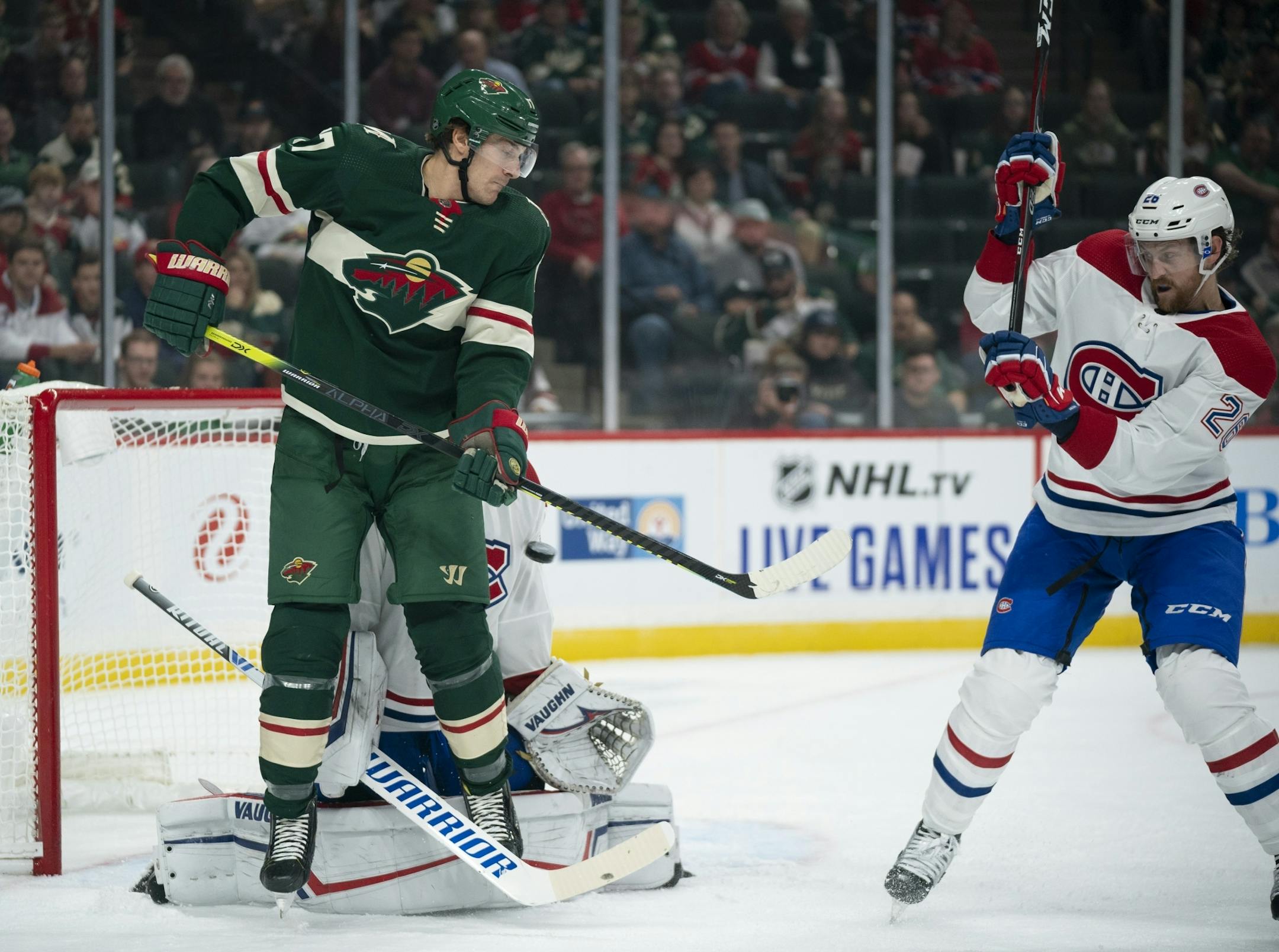 Minnesota Wild left wing Marcus Foligno (17) tried to deflect an incoming puck in front of Montreal Canadiens goaltender Keith Kinkaid and defenseman Jeff Petry (26) in the first period.